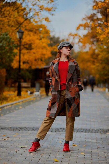 Photo a woman is walking down a street wearing a coat with a hat on it