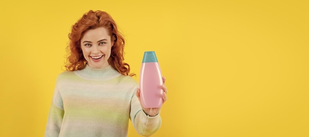 Woman isolated face portrait banner with copy space happy redhead woman with shampoo bottle shampooing hair in salon girl with hair conditioner