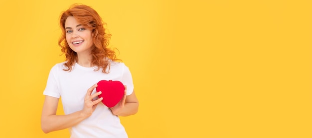 Woman isolated face portrait banner with copy space lady on yellow background love present cheerful redhead woman with love romantic gift