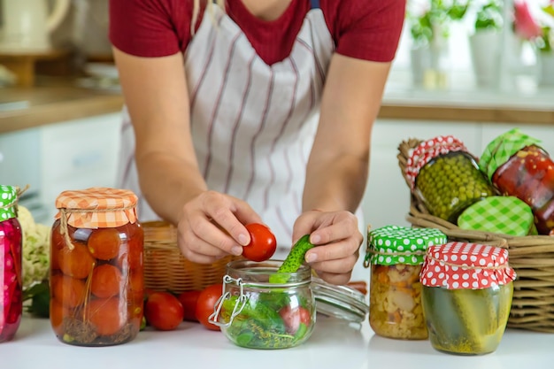 Woman jar preserve vegetables in the kitchen Selective focus