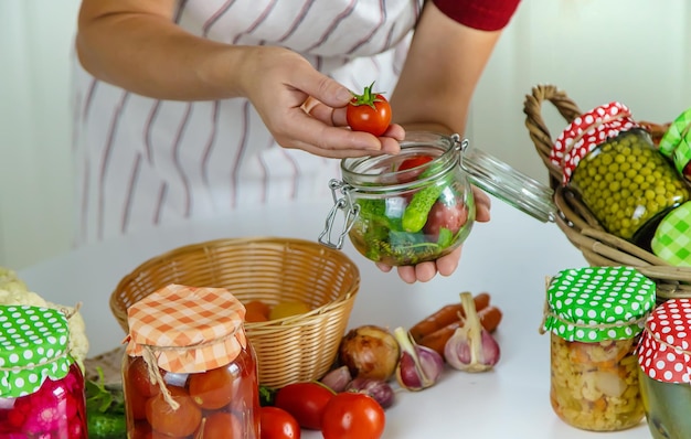 Woman jar preserve vegetables in the kitchen Selective focus