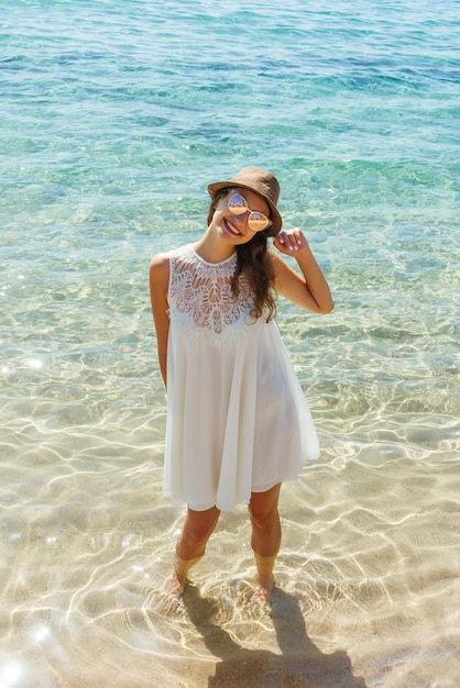 Woman joyful and happy in white dress at the beach