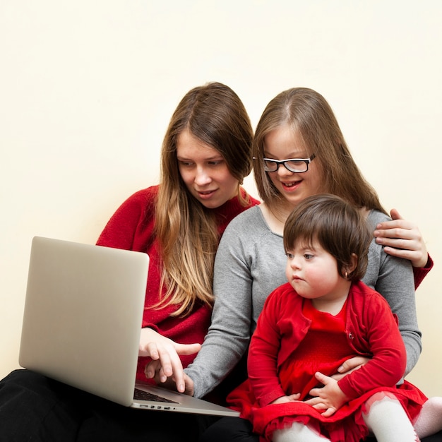 Woman and kids with down syndrome looking at laptop