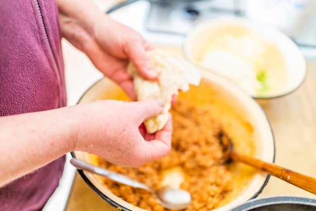 A woman in the kitchen prepares a dish of Golubtsi