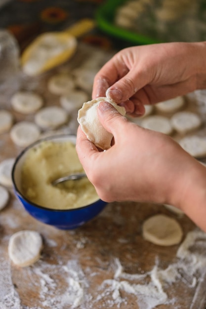 Woman in the kitchen prepares dumplings for breakfast Ukrainian folk dish