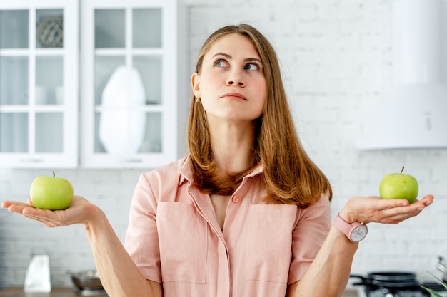 Woman in kitchen ready to prepare meal with vegetables and fruits. 