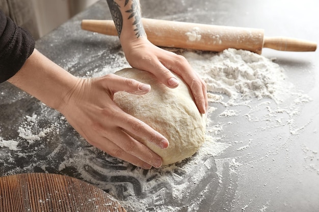 Woman kneading dough on kitchen table