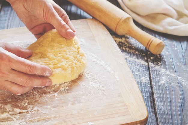 Woman kneading a dough on the table