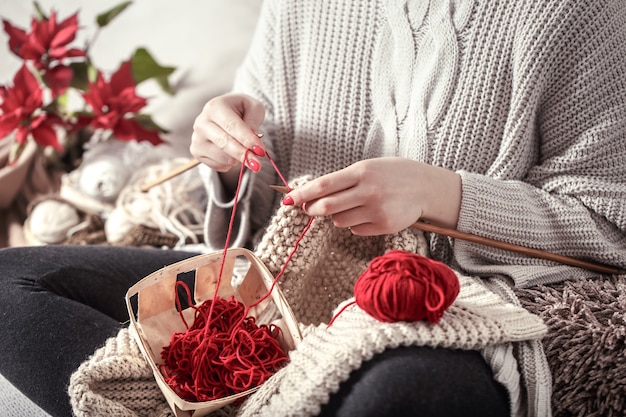 woman knits knitting needles on the couch