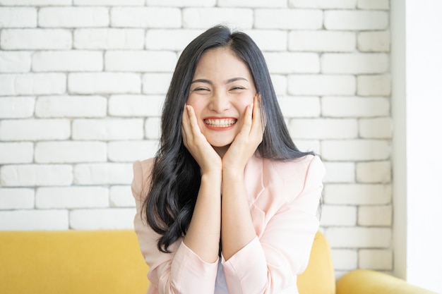 A woman laughing happily, being alone in a resting room