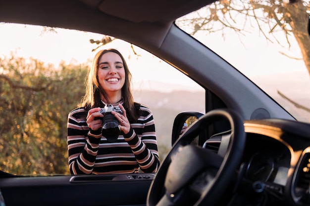 Woman laughing happy with a photo camera in hands