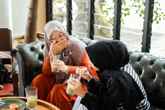 woman laughing and make a joke with her friend at cafe