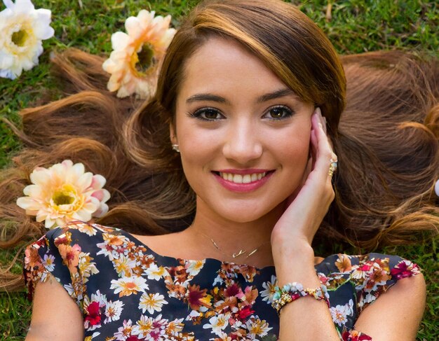 a woman laying on the grass with flowers in her hair