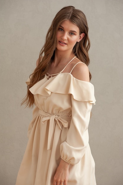 A woman in a light brown dress with a bow on the back