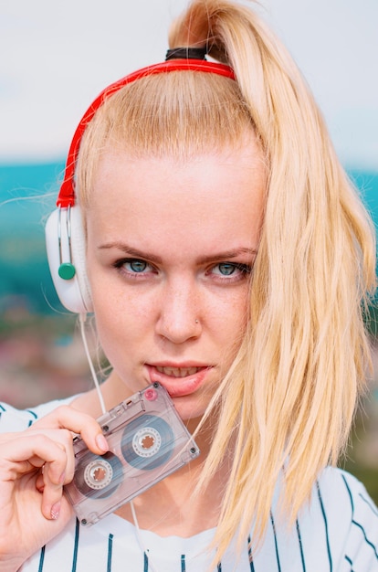 Woman listening music with cassette and headphones emotional portrait girl retro player