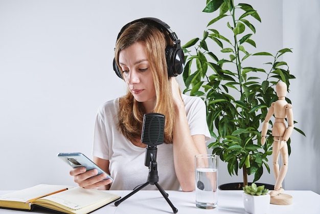 Woman listening online course in headphones distance education Freelancer sitting at workplace and procrastinating Lazy and distracted employee