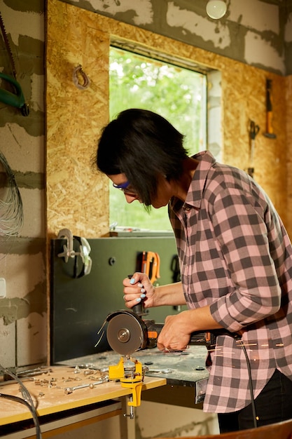 Woman locksmith works with grinder machine fly bright sparks