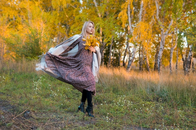 Woman in a long coat in autumn forest