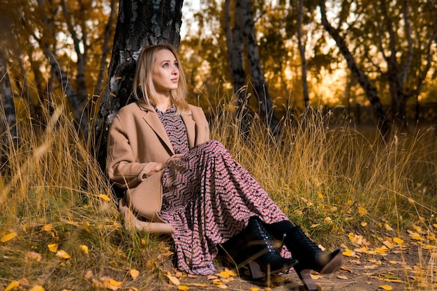 Woman in a long coat in autumn forest