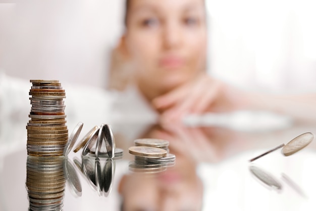 Woman look on pile of coins, column of coins falls , business crisis concept. shallow focus. High quality photo