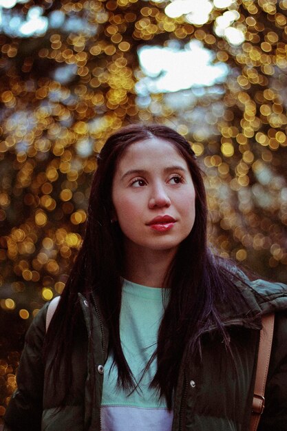 Woman looking away against trees