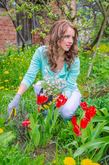 Photo woman looking away while gardening in yard