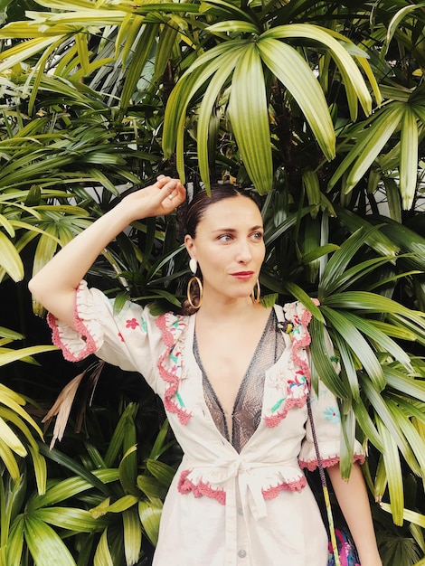 Photo woman looking away while standing against plants