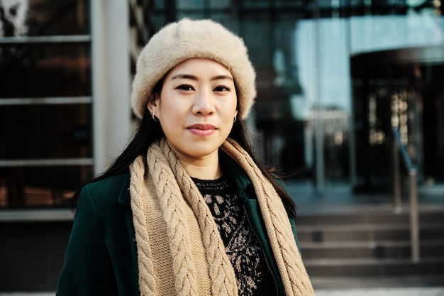 Woman looking at camera while posing outside office building.