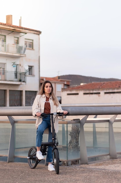 Woman looking at camera while riding an electric bike going home to a poor european town with copy space