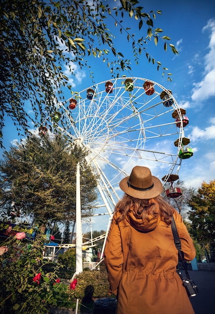 Woman looking at Ferris wheel in the park