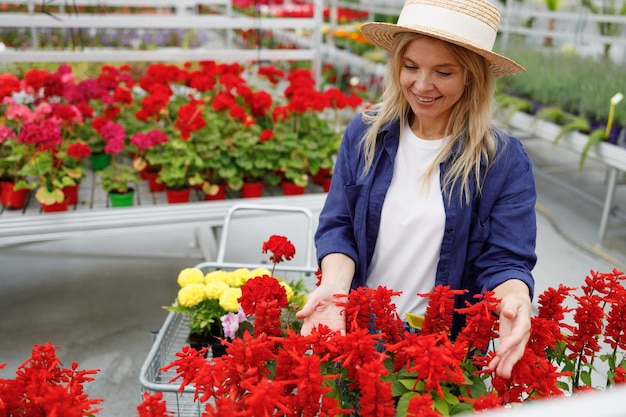 Woman looking at flowers while walking in a greenhouse