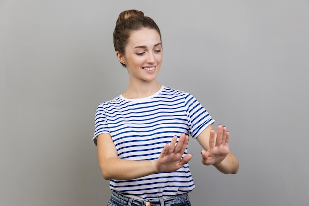 Woman looking at her nails with toothy smile admires her freshly painted nails