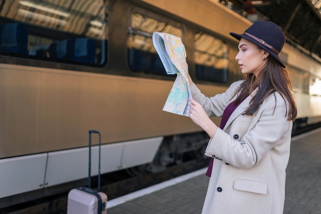 Woman looking at the map on the railway station.