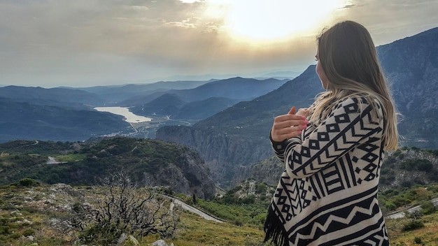 Woman looking at mountains during sunset