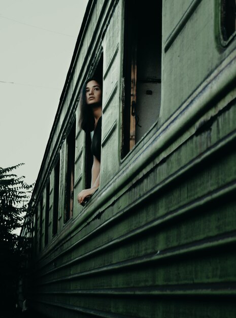 Photo woman looking through window of train