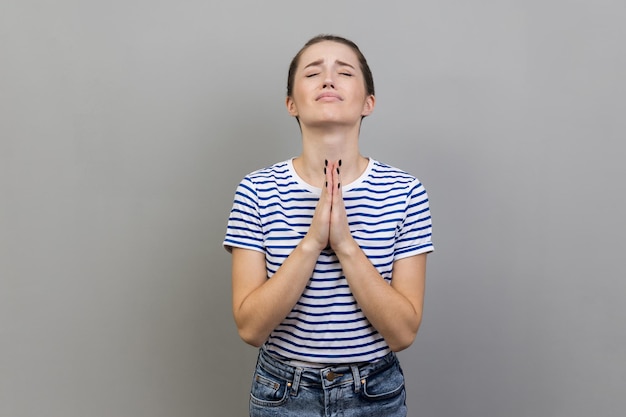 Woman looking up with imploring desperate grimace praying to god asking for help