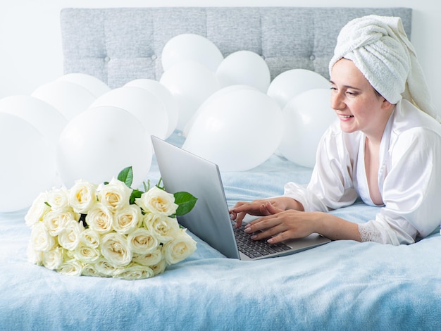 Woman lying on bed with decorations with balloons for Birthday party