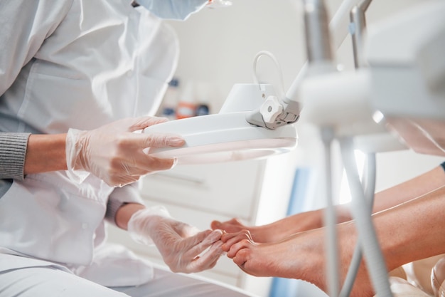 Woman lying down and have operation on her feet by professional clinic worker