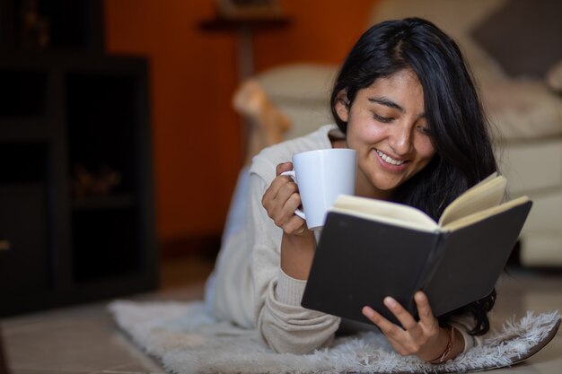 Woman lying down reading with cup of coffee