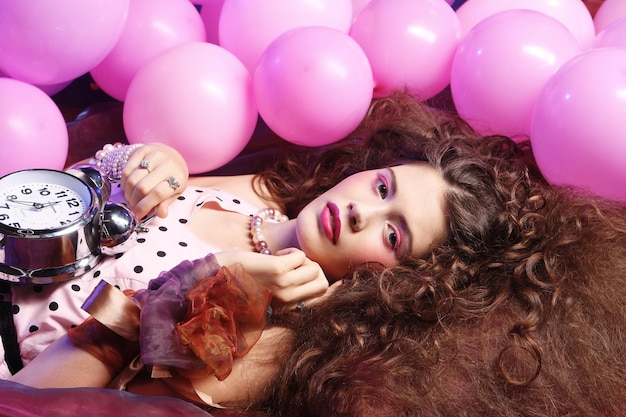 Woman lying on floor among balloons