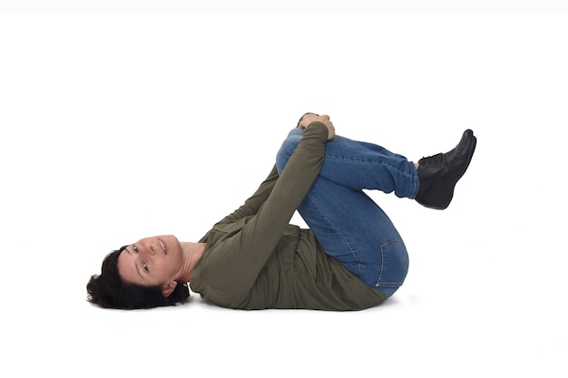 Photo woman lying on the floor knees holding and looking at camera on white background