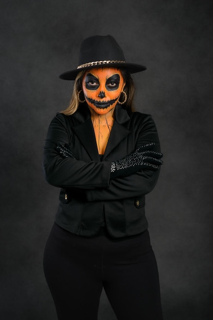 Woman made up as a pumpkin looking at the camera Halloween makeup