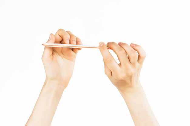 woman makes herself a manicure on a white background