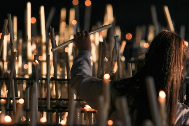 A woman makes an offering with a candle in a catholic church