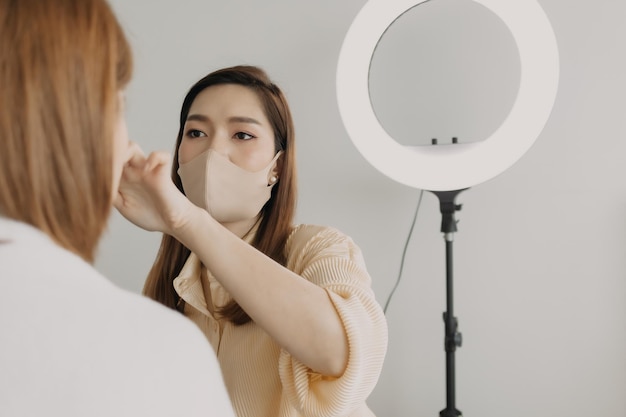 Woman makeup artist is at work and wearing makeup on her model