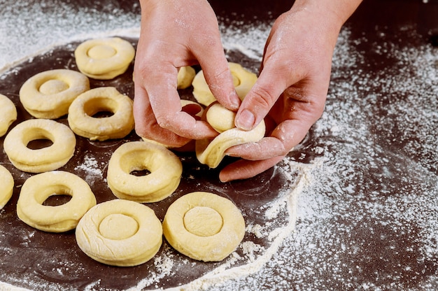 Photo woman making american donuts and munchkins from raw yeast dough