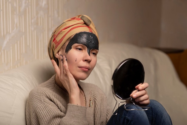 Woman making black clay face mask at home