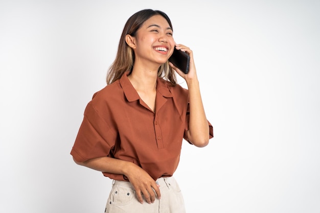 Woman making a call using a cell phone on isolated background