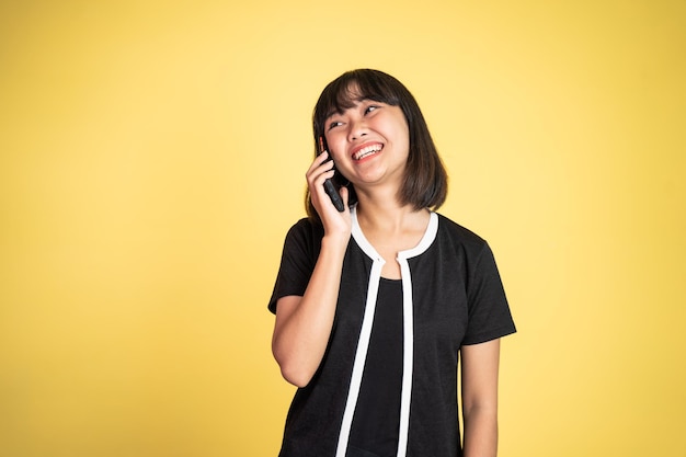 Woman making a call using a cell phone on isolated background