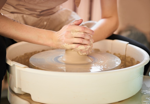 Woman making ceramic pottery on wheel, creation of ceramic ware.